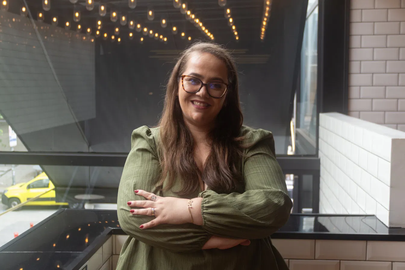 Eliscarla Bragança Barbosa Mota, psicóloga clínica, em pé de braços cruzados, sorrindo